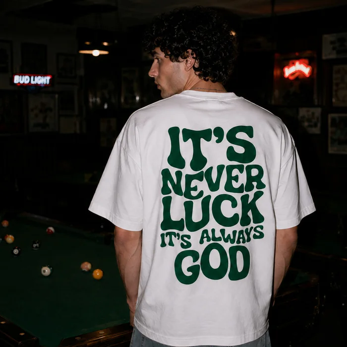 Back of a white T-shirt with a green graphic print.