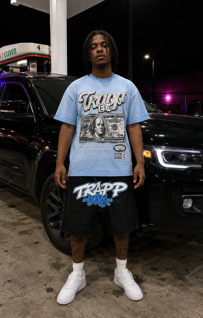 Man in a blue T-shirt standing at a gas station.