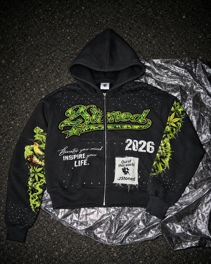 Dark hoodie with green graphics laid flat for a product photograph.